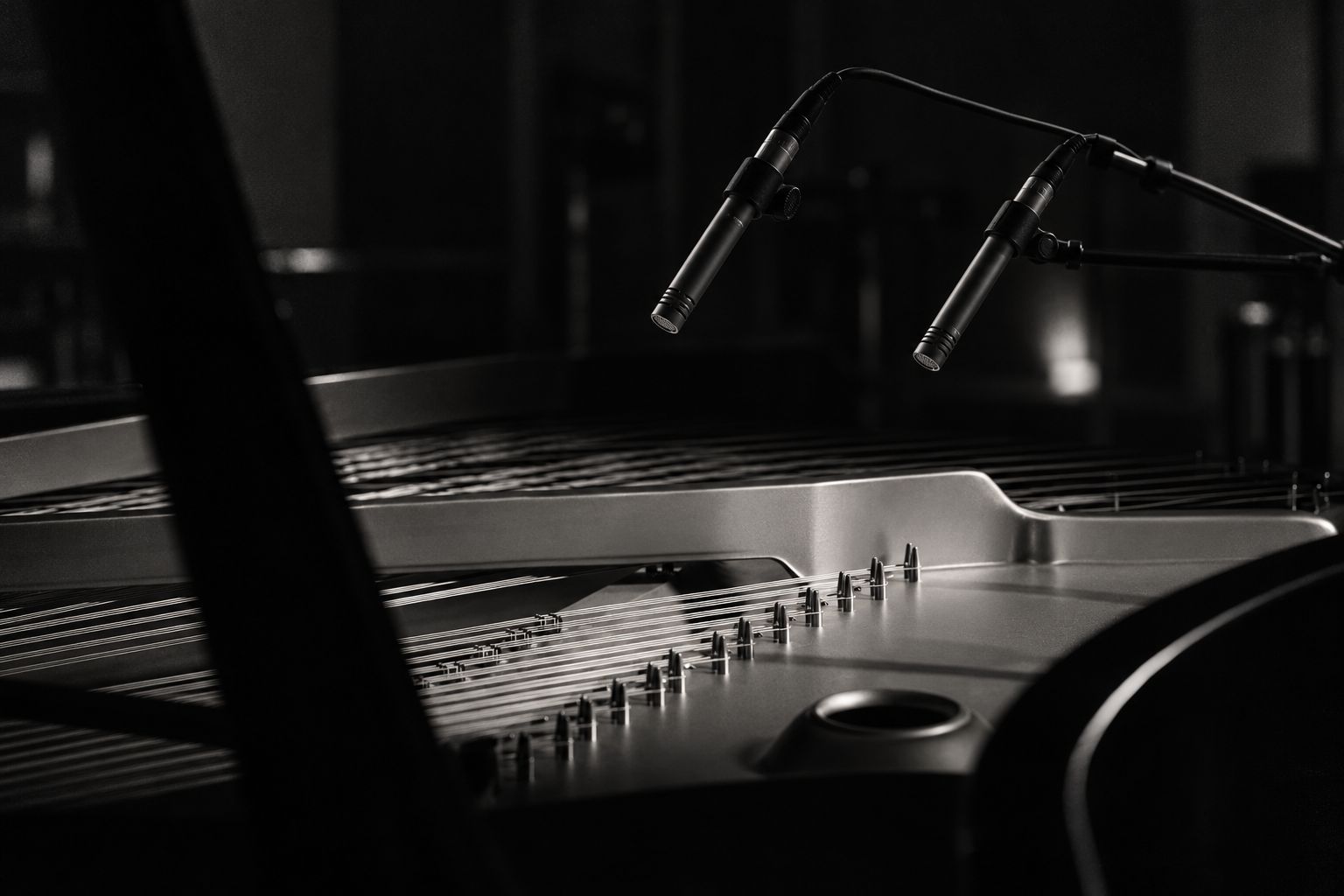 Coppia di microfoni sopra le corde di un pianoforte a coda